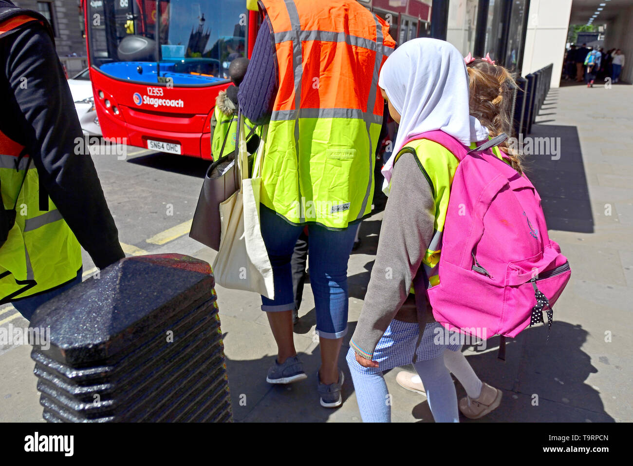 London, England, UK. Die Schüler warten mit dem Bus zu erreichen - junge Mädchen mit Kopftuch Stockfoto