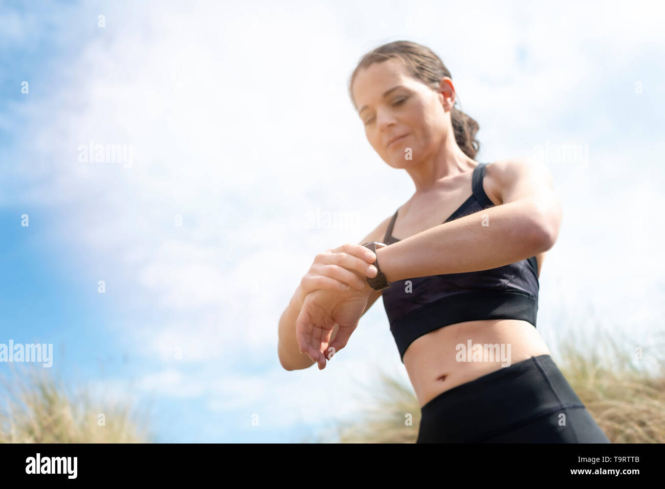 Frau jogger Ihre smart Watch, Herzfrequenz, Kalorien, Anzahl der Schritte Stockfoto
