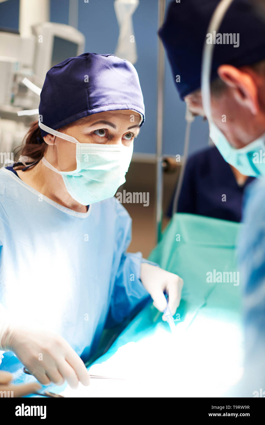Weibliche Chirurg über OP-Tisch Stockfoto