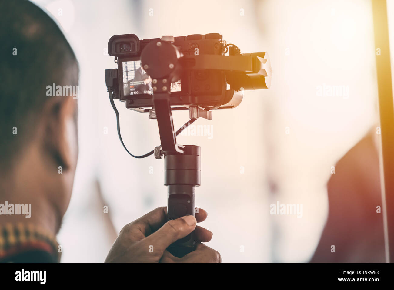 Videographer Aufzeichnen von Videos mit spiegellosen Digitalkamera auf Gimbal Stabilisierungssystem Stockfoto