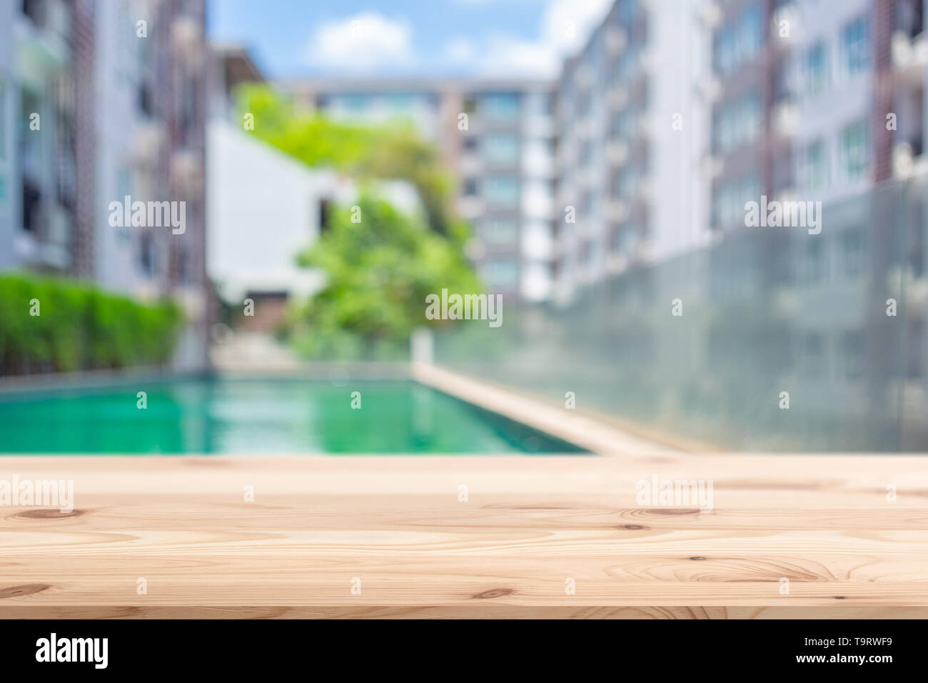 Holz- Tischplatte mit Eigentumswohnung Unterkunft blur Hintergrund für Werbung Vorlage Stockfoto