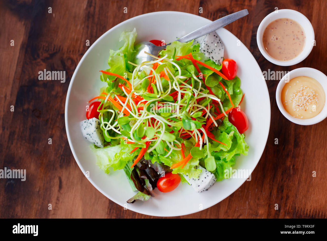 Gemüse Obst gemischter Salat mit Sauce, saubere und gesunde Lebensmittel für Vegetarier low fat High fiber Draufsicht auf hölzernen Tisch Stockfoto