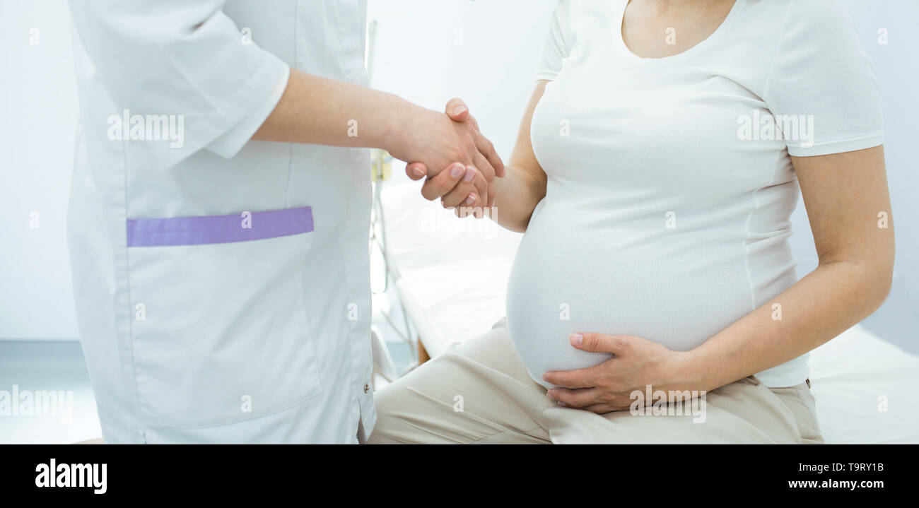 Schwangere Frau schütteln Doctor's Hand. Beratung Schwangerschaft Frau, pränatale Versorgung Stockfoto