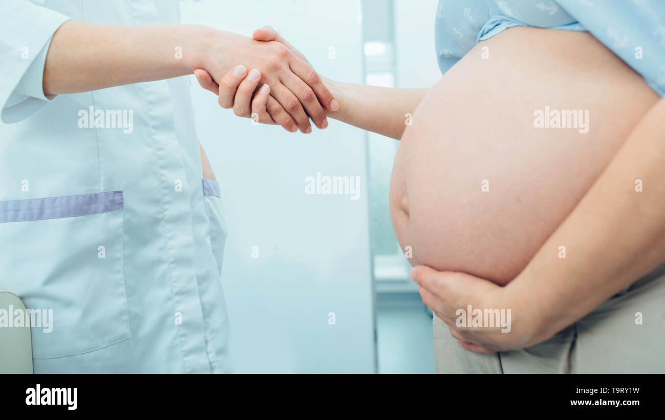 Schwangere Frau schütteln Doctor's Hand. Beratung Schwangerschaft Frau, pränatale Versorgung Stockfoto
