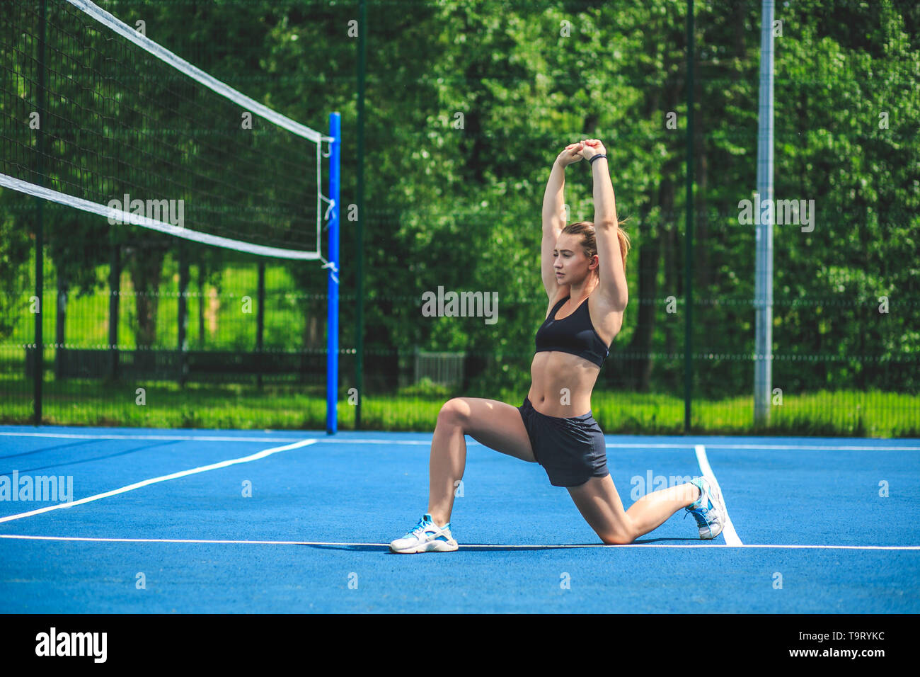 Sportliche Frau, Stretching und arbeiten Sie auf dem blauen Tennisplatz in Moskau Yauza Park. Stockfoto