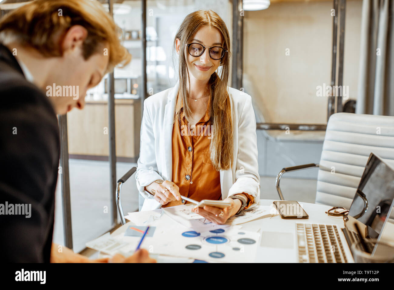 Junger Mann und Frau, die ein ernstes Geschäft Gespräch, Arbeit mit Papierdokumenten und Computer im Büro Stockfoto