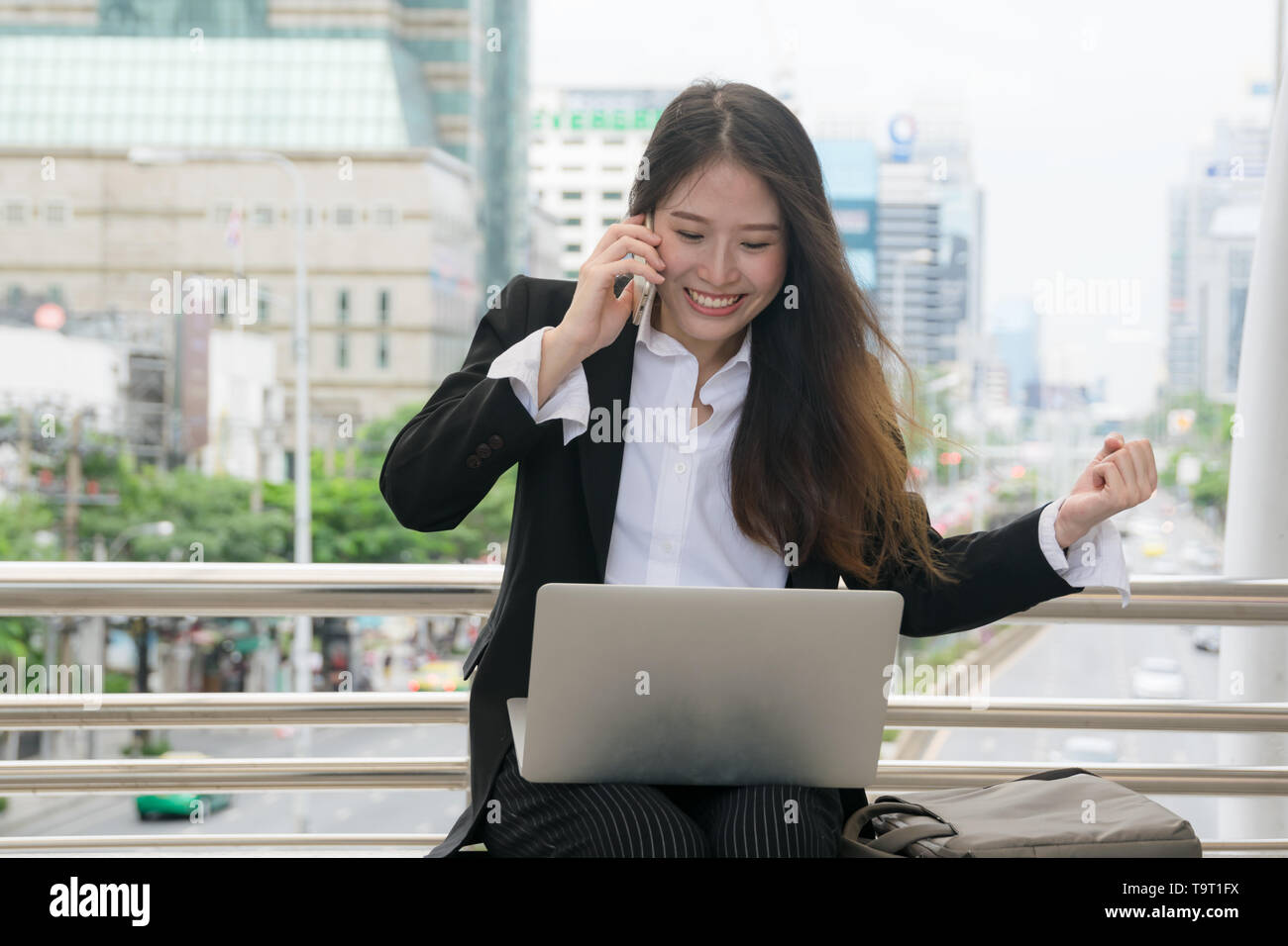 Asian Business Frau mit Laptop und Mobiltelefon mit glücklichen Gesicht, Konzept Erfolg arbeiten Stockfoto