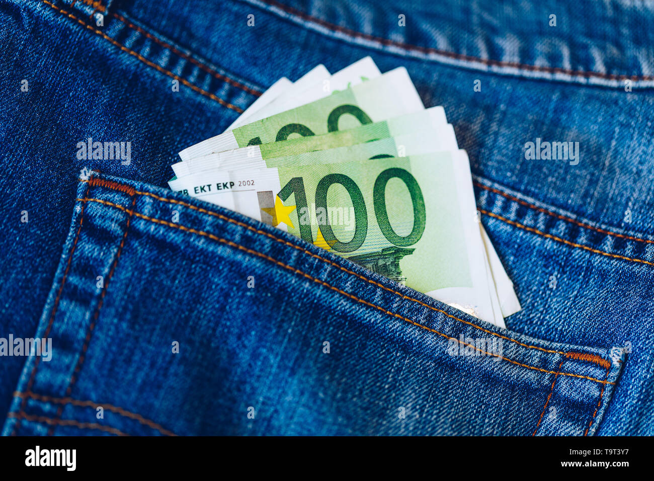 Euro Rechnungen in Jeans pocket Hintergrund. Euro-banknoten in Jeans Gesäßtasche. Konzept der reiche Leute, Speichern oder Geld auszugeben. Euro Rechnungen herausfallen. Stockfoto