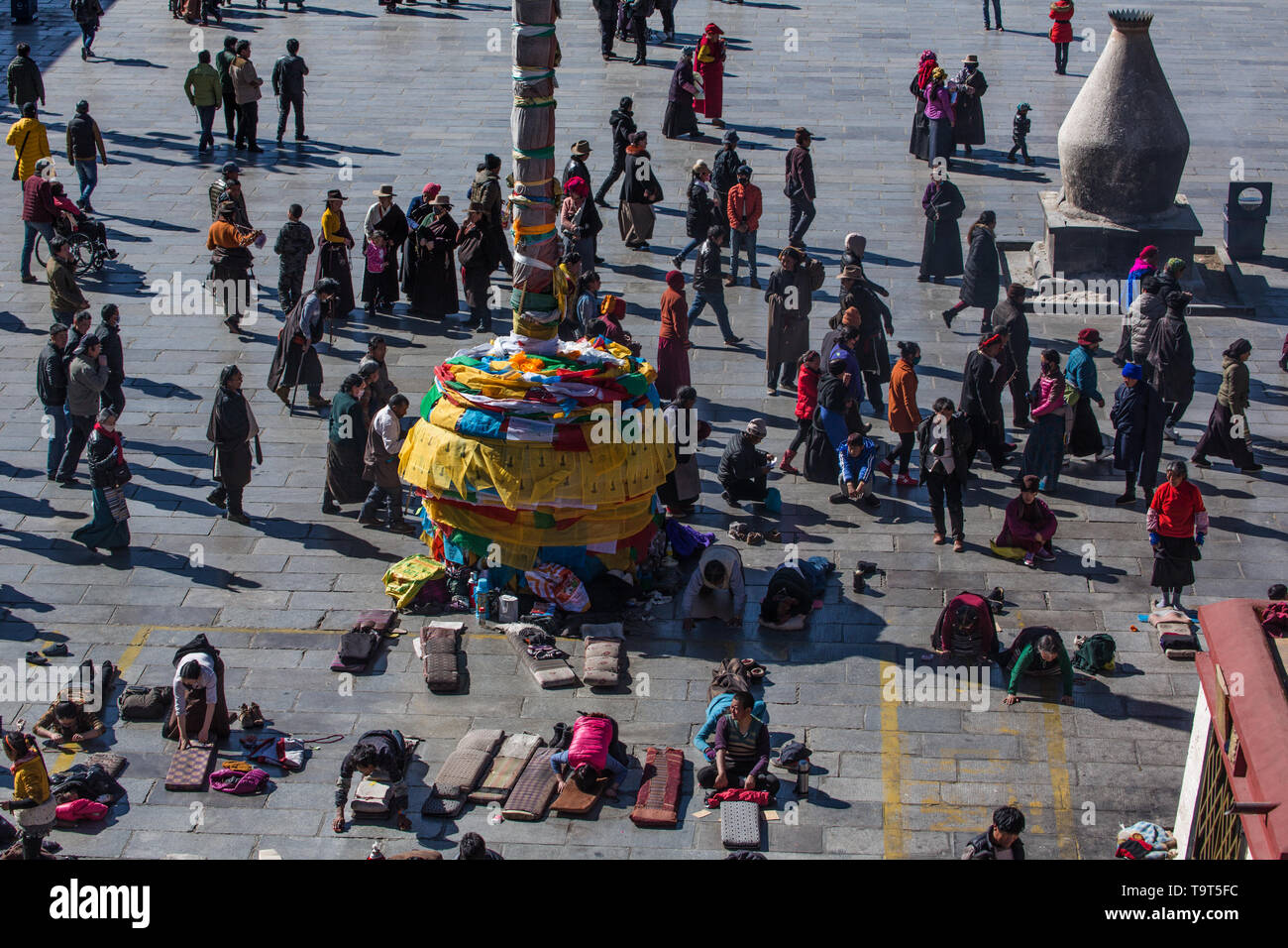 Tibetischen pilgern umrunden um und sich selbst vor dem Jokhang Tempel in Barkhor in Lhasa, Tibet niederzuwerfen. Auf der rechten Seite ist ein großer Stockfoto