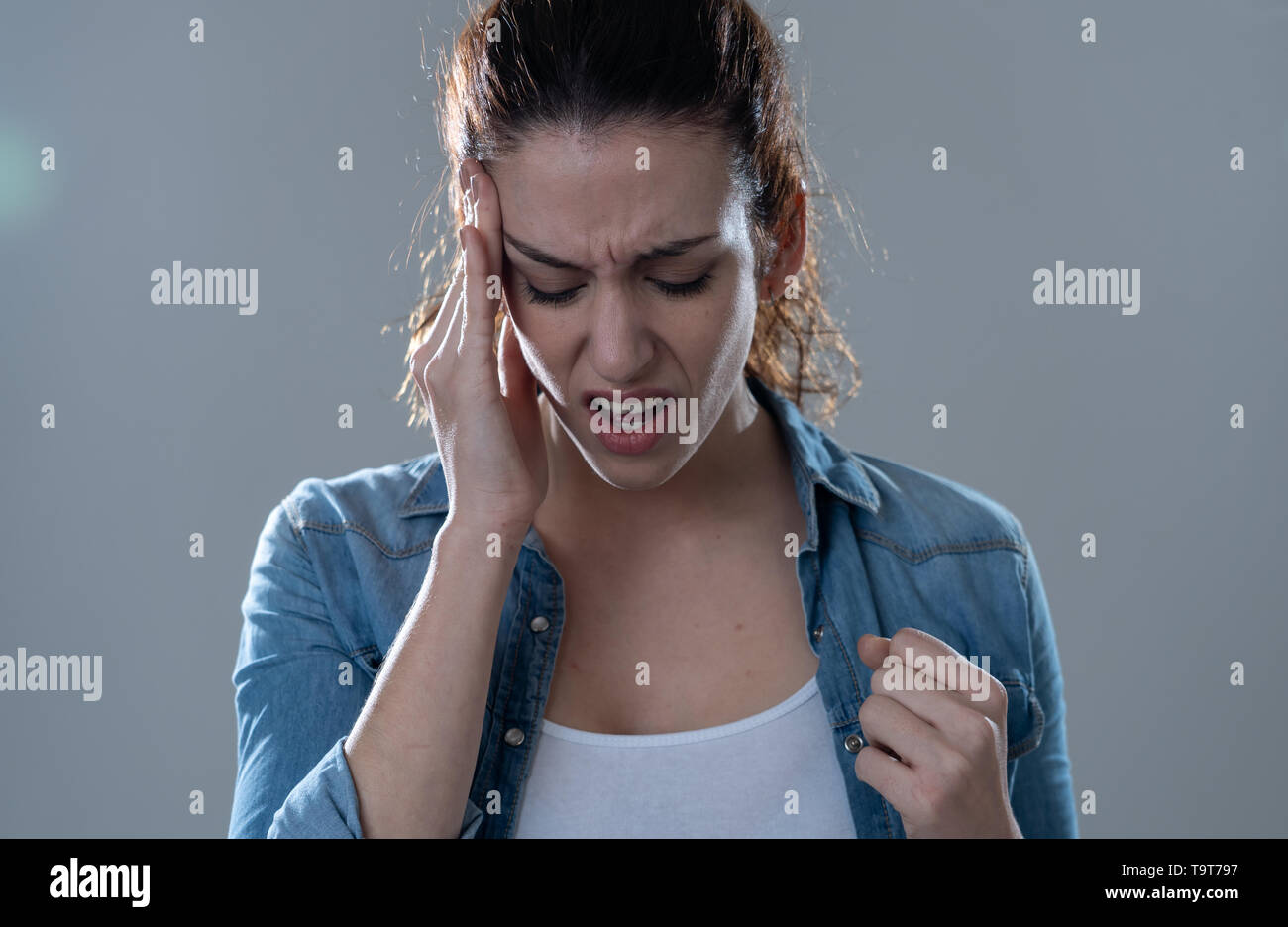 Nahaufnahme, Porträt einer jungen Frau auf der Suche besorgt und nachdenklich Migräne leiden unter großen Schmerzen. Auf neutralem Hintergrund isoliert. In der Gesichtsbehandlung ex Stockfoto