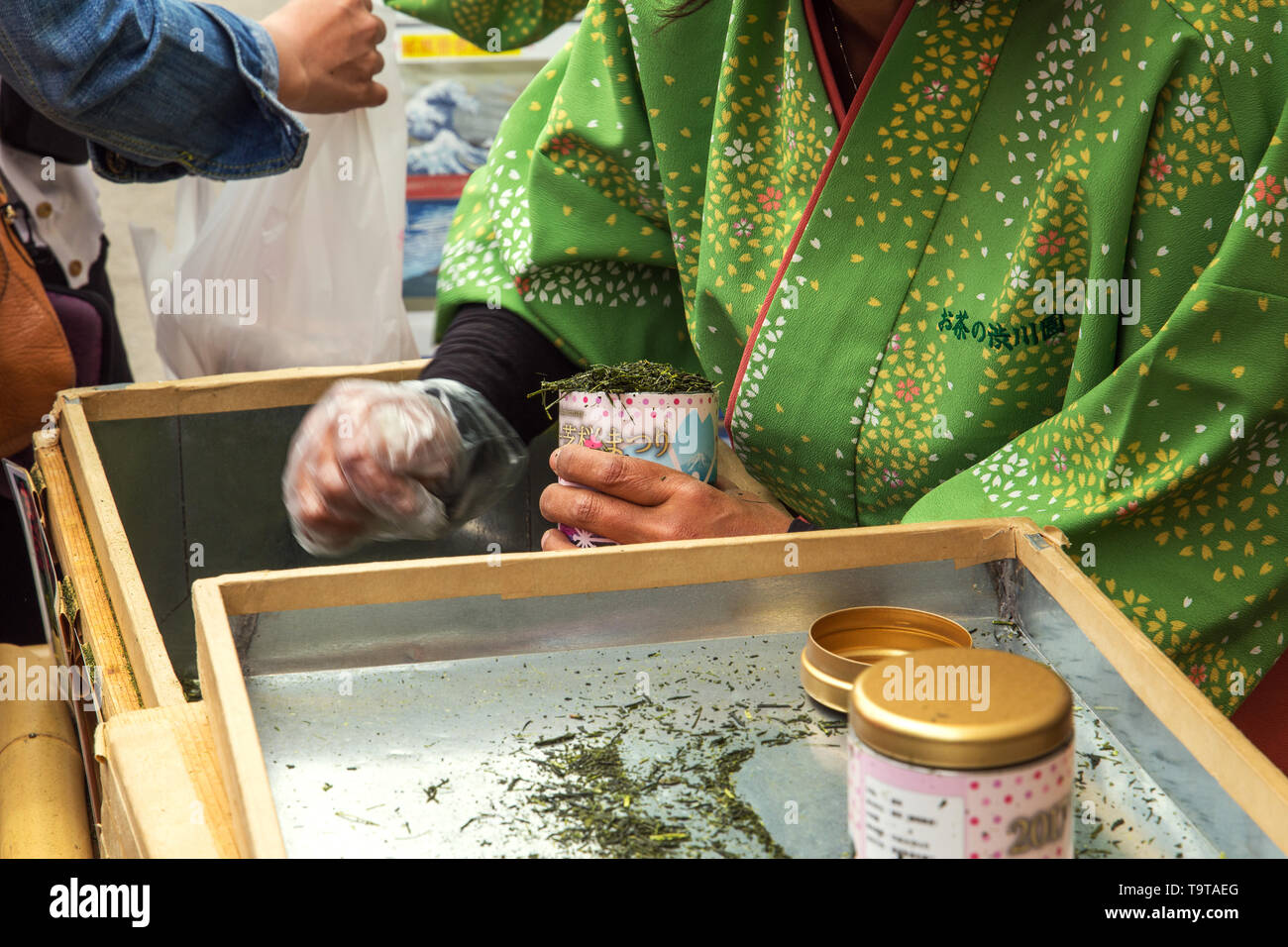 Japanische Frau füllen, mit grünem Tee Blätter am Mount Fuji Sakura Festival, Japan. Stockfoto