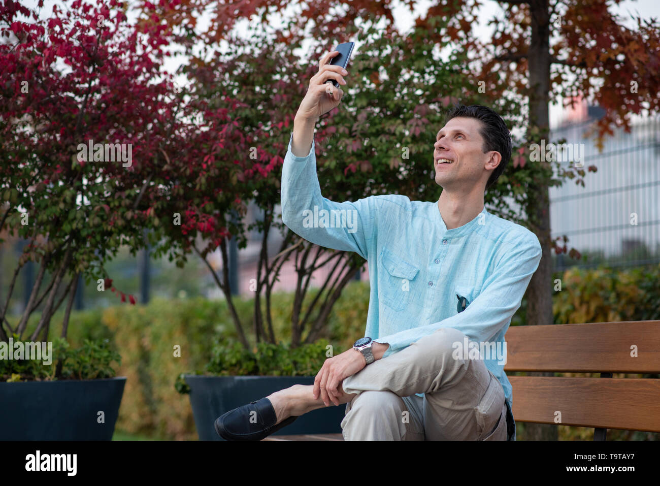 Fröhlicher Mann unter selfie mit seinem Handy in einem Park Stockfoto