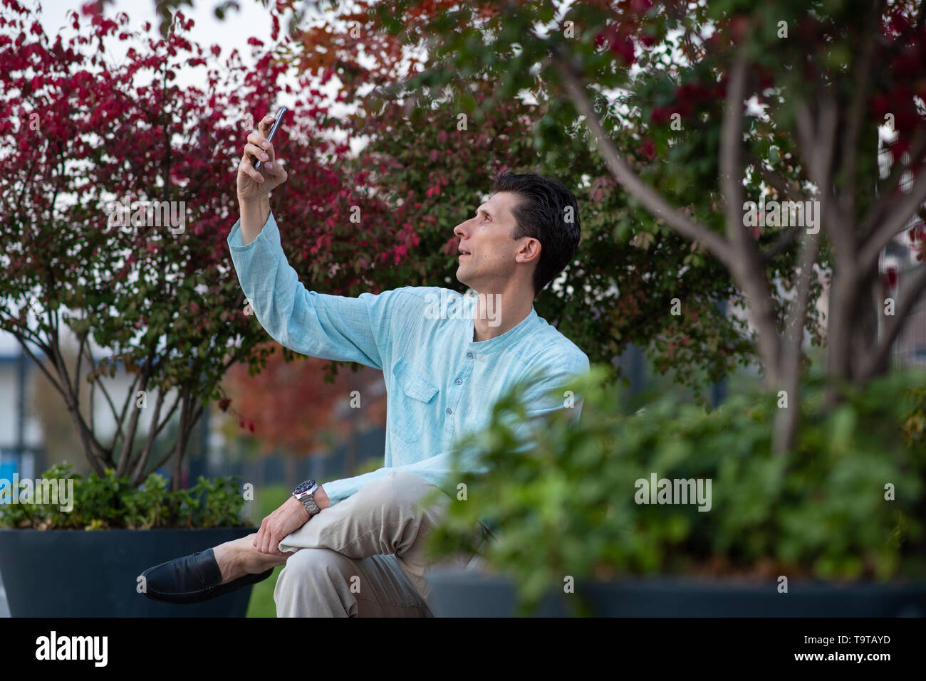 Schöner Mann unter selfie mit seinem Handy in einem Park Stockfoto