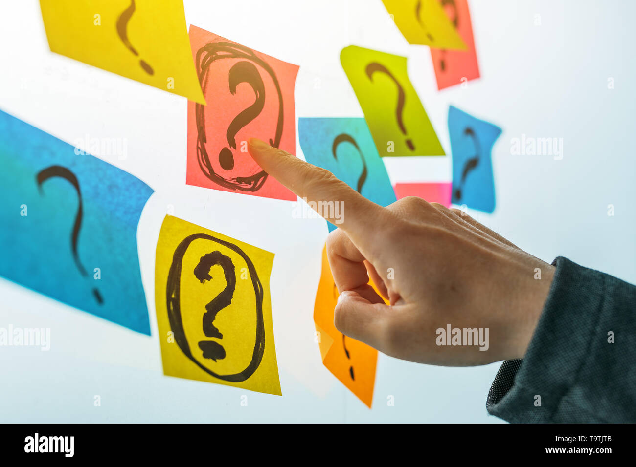 Geschäftsfrau, Fragen zu stellen in der Lage, weibliche Business person Hand zeigen Markierungen auf bunte Zettel geschrieben in Frage zu stellen Stockfoto