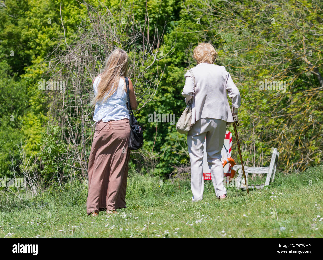 Zwei Frauen, die nicht Mutter werden kann oder und Tochter suchen von hinten zu Fuß an einem warmen Tag in der Natur im Frühjahr in Großbritannien. Stockfoto