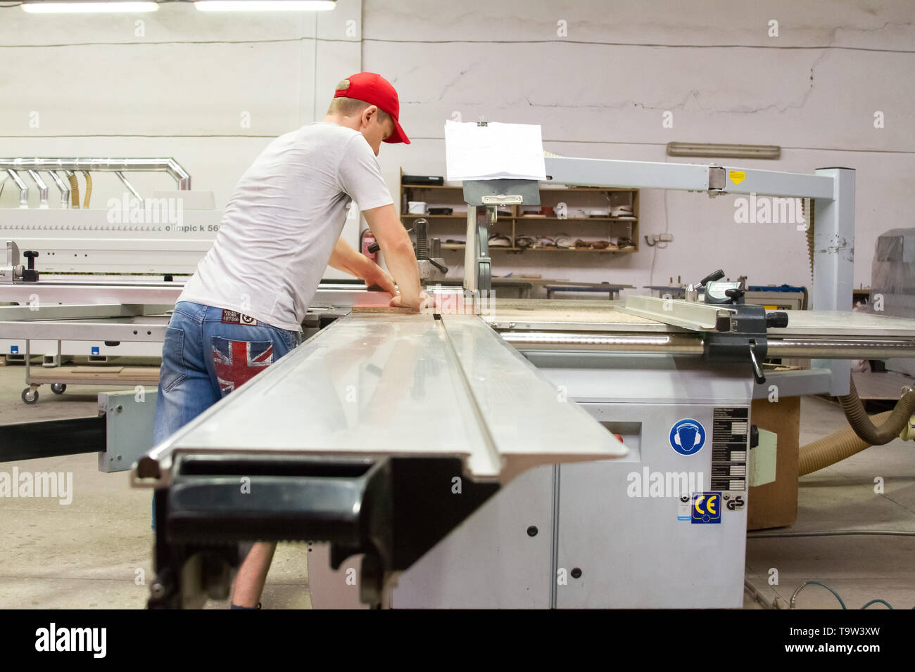 Ein männlicher Mitarbeiter kontrolliert die Arbeit der Maschine im Möbel Shop. Stockfoto