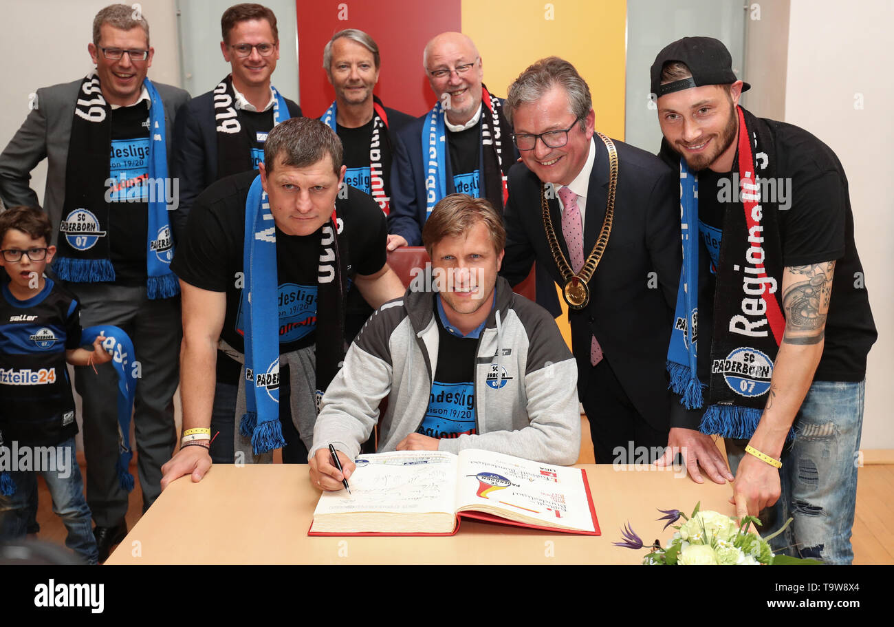 Paderborn, Deutschland. 20 Mai, 2019. Fussball: Bundesliga, SC Paderborn promotion Party. Die Paderborner trainer Steffen Baumgart (L-R), Geschäftsführer Sport Markus Krösche, Paderborn Bürgermeister Michael Dreier (CDU) und Christian Strohdiek Zeichen in das Goldene Buch der Stadt. Die Spieler der Mannschaft mit den Fans auf der Bühne vor dem Rathaus die Förderung der Verein in der 1. Fussball Bundesliga feiern. Credit: Friso Gentsch/dpa/Alamy leben Nachrichten Stockfoto