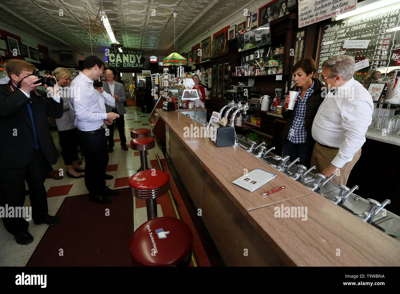 Wilton, Iowa, USA. 20 Mai, 2019. Candy Küche Inhaber Lynn Ochiltree, Recht, Uhren, wie Iowa Gouverneur Kim Reynolds schmeckt Ihr altmodische soda fountain trinken, nachdem Sie die Stärken des ländlichen Iowa Rechnung in Gesetz vor dem Geschäft in Wilton, Iowa Montag, 20. Mai 2019 unterzeichnet. Credit: Kevin E. Schmidt/Viererkabel - Zeiten/ZUMA Draht/Alamy leben Nachrichten Stockfoto