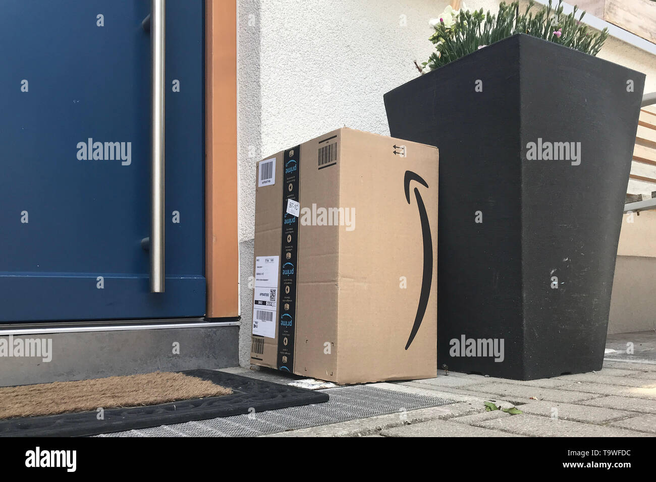 München, Deutschland. 18 Mai, 2019. Amazon Paket steht vor einer Haustür  unsachgemäße Paketversand. Mehr und mehr wurden Pakete, die vom Empfänger  nicht, einfach vor oder auf der Tür hinterlegt akzeptiert werden kann.