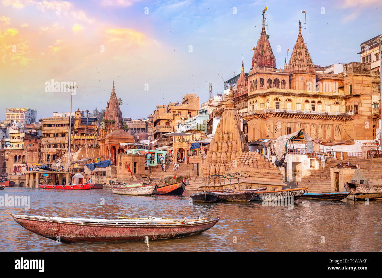 Alte Varanasi Stadt Architektur mit Blick auf Holz- Boot auf dem Fluss Ganges bei Sonnenuntergang Stockfoto Alte Varanasi Stadt Architektur mit Blick auf Holz- Boot auf dem Fluss Ganges bei Sonnenuntergang Stockfoto