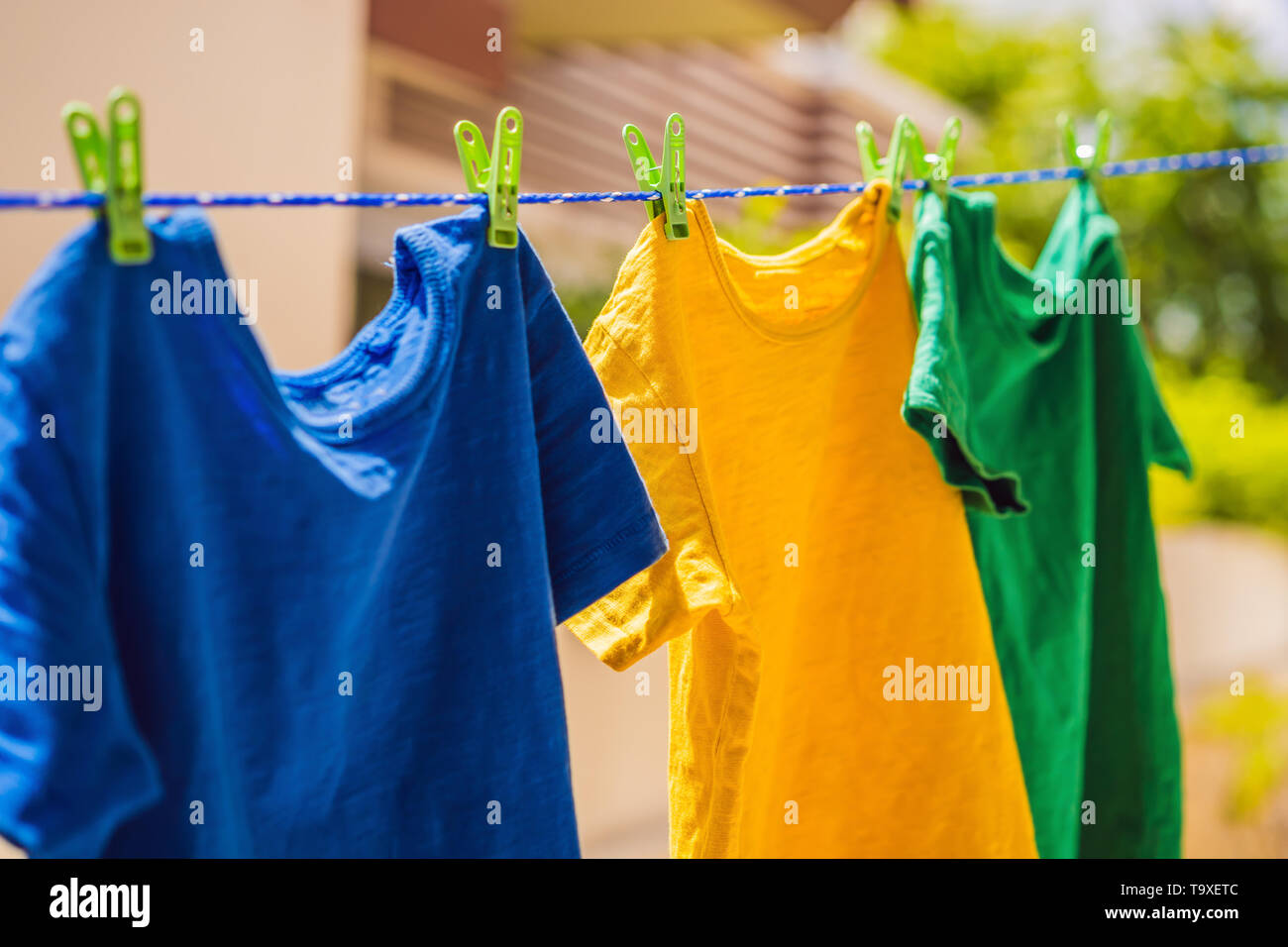 Multicolor Hemden auf Wäscheleinen im sonnigen Tag Stockfoto