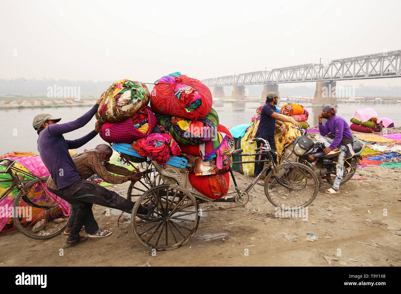 02/12/2019 Agra Indien Menschen laden gewaschene Wäsche in Ballen auf einer Big Bike (in der Nähe von Fluss Jamna) Stockfoto