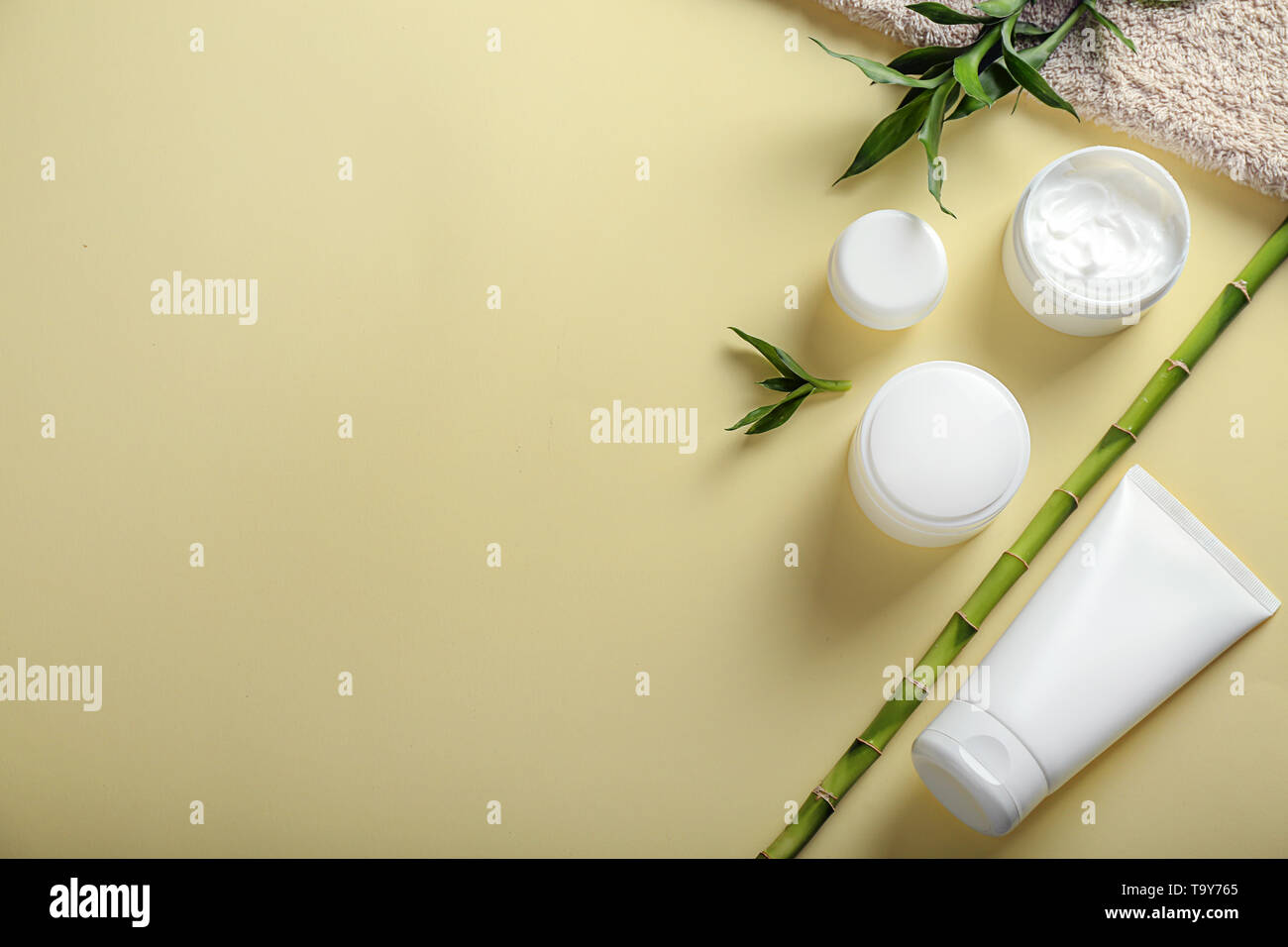 Gläser und Rohr mit Körper Creme auf farbigen Hintergrund Stockfoto