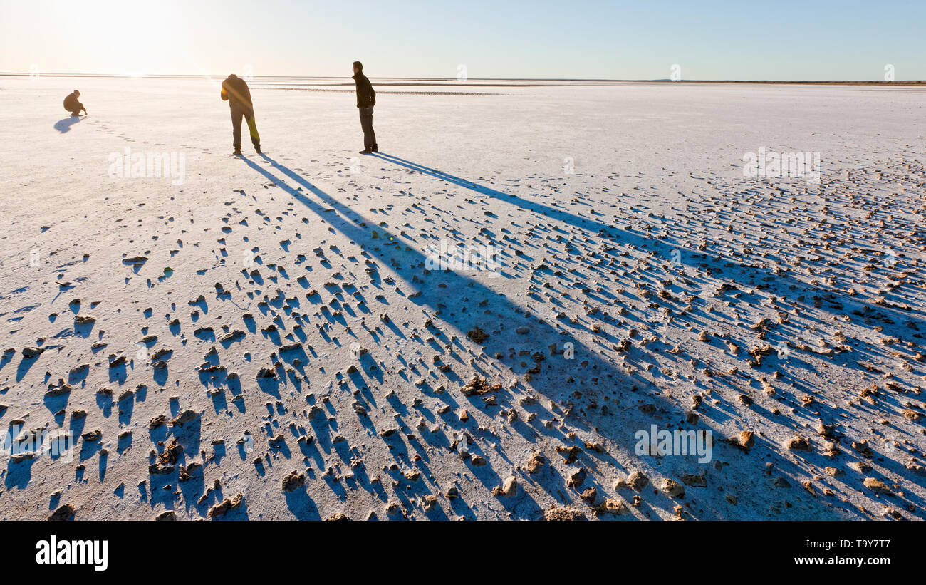 Gruppe von Männern Trockensalz Bett des Lake Eyre South bei Sonnenaufgang zu erkunden. Stockfoto