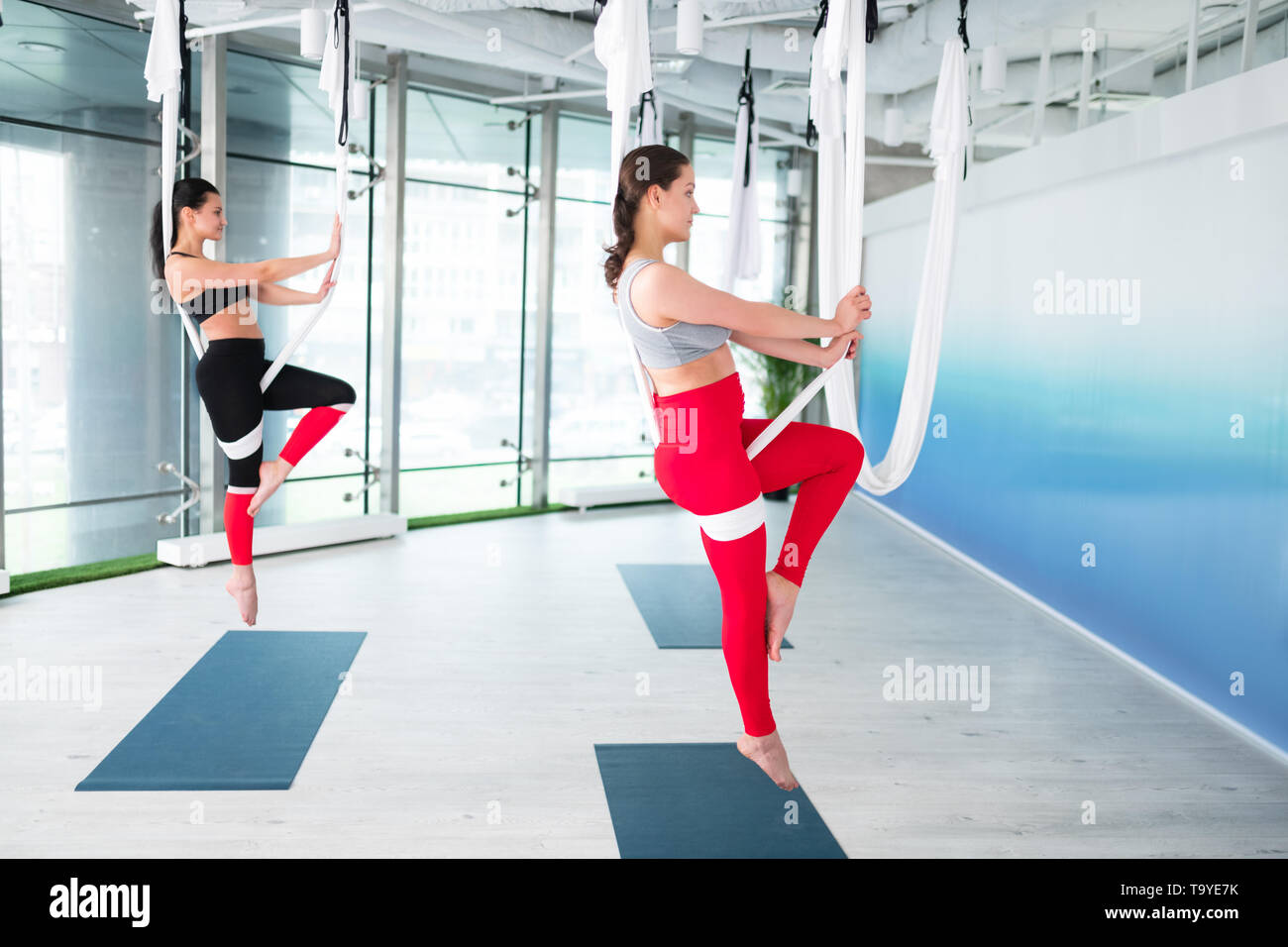 Zwei schlanke Frauen mit Leggings und oben tun antigravity Yoga Stockfoto