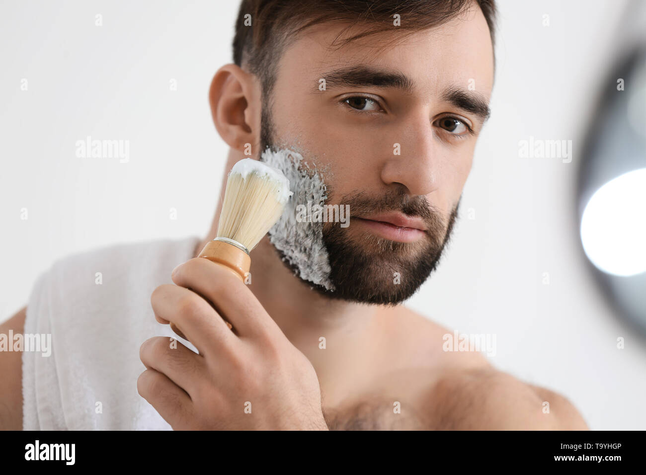 Schöner mann Rasieren im Badezimmer Stockfoto