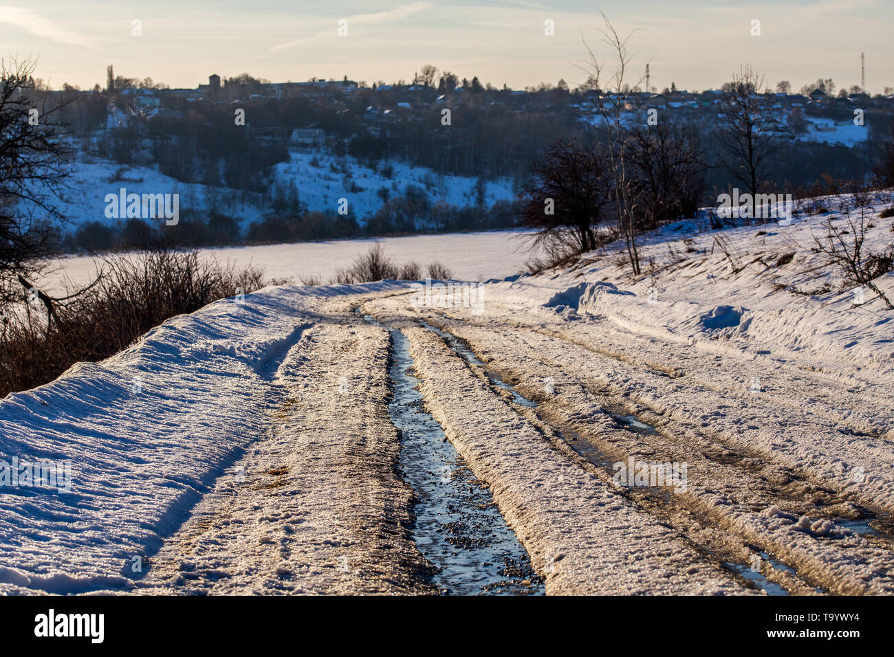 Rustikale Straßenpiste im Winter tauen das Tageslicht auf, ohne dass jemand und gezielter Fokus auf die Straße kommt Stockfoto