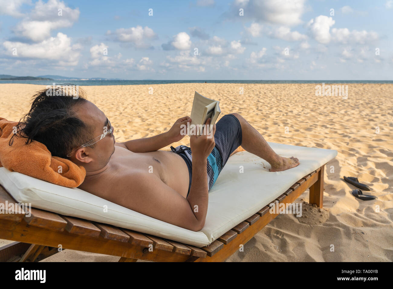 Mann mit einem guten Buch in schönen Strand entspannen Stockfoto