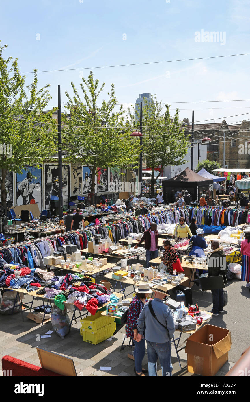 Open-air-Markt in Deptford, südöstlich von London, UK. Zeigt Racks von Kleidung und Tabellen mit inländischen Artikel zum Verkauf. Kunden surfen. Stockfoto