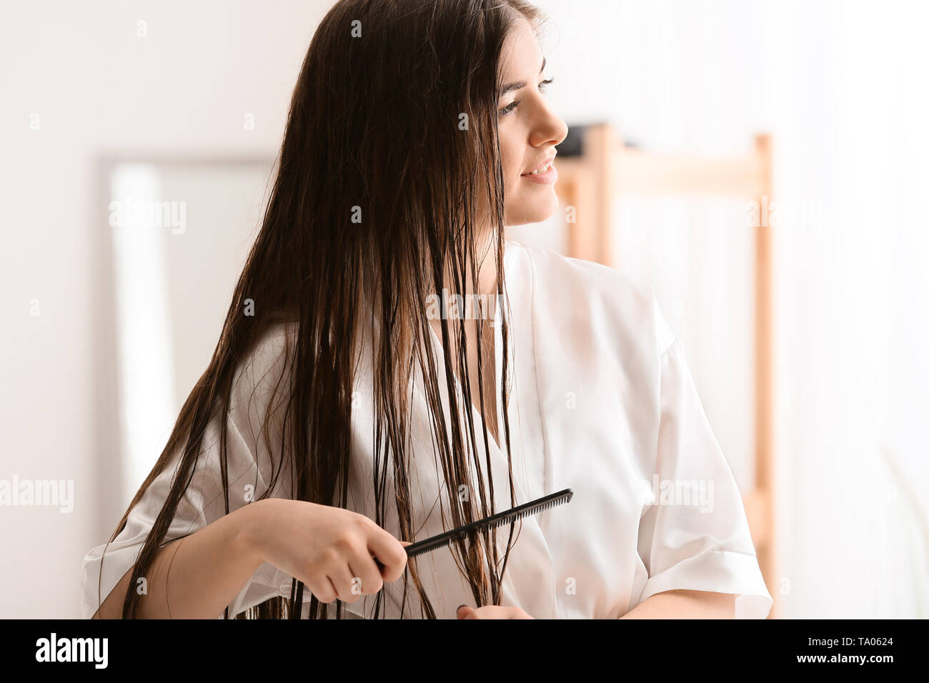 Junge Frau kämmen schöne lange Haare im Bad Stockfoto