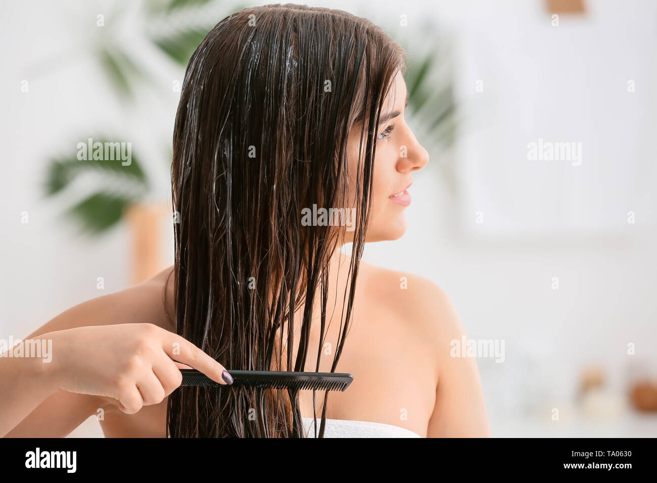 Junge Frau kämmen schöne lange Haare im Bad Stockfoto