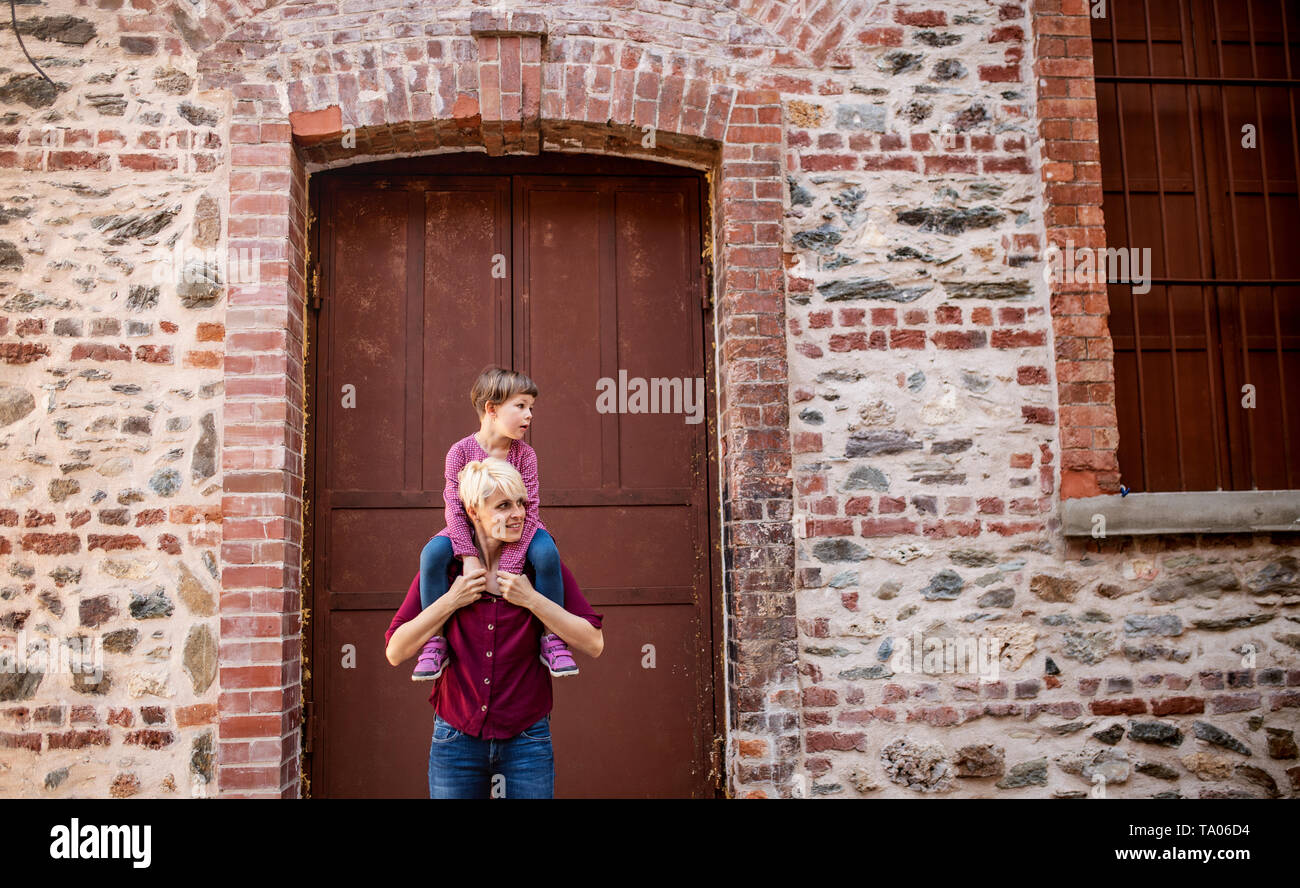 Vater mit kleinen Tochter stand draußen auf der Straße in der Stadt, was eine piggyback Ride. Stockfoto