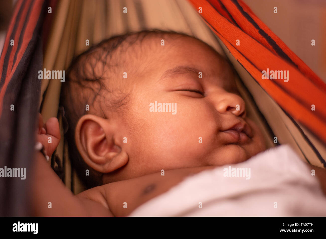 Nahaufnahme von niedlichen kleinen New Born Baby schlafen in der Wiege aus Sari in Indien. Stockfoto