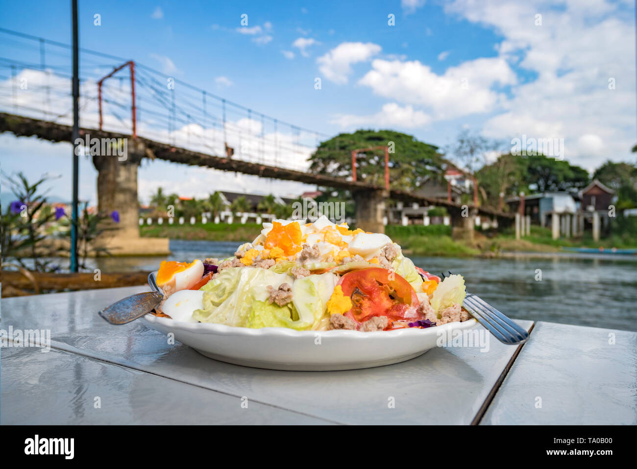 Leckeren Salat ist ein Gericht der Nationalen laotischer Küche. Im Freien essen. Serviert Gerichte im Restaurant auf dem Tisch gegen den Fluss. Asiatische Küche. Stockfoto