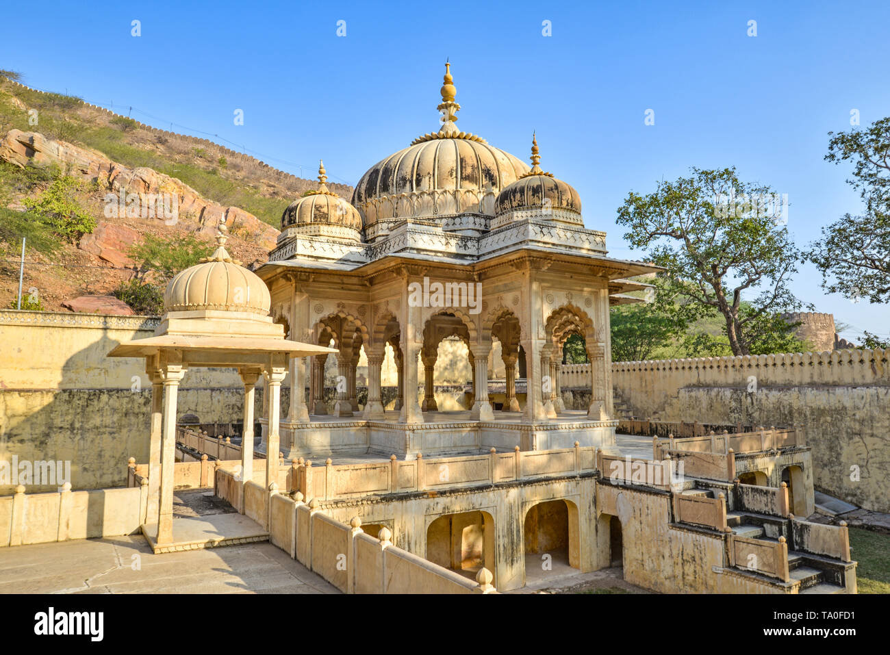 Man hauptsächlich beige Kenotaph im Schatten von Bäumen an der Königlichen Gaitor, Jaipur, Rajasthan, Indien Stockfoto