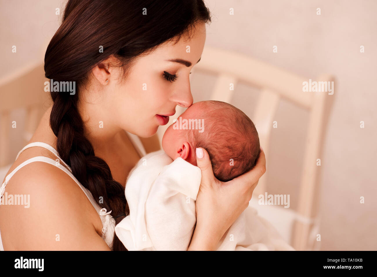 Schöne Frau mit neugeborenen Baby im Zimmer Nahaufnahme. Schauen einander an. Mutterschaft. Motehrhood. Stockfoto