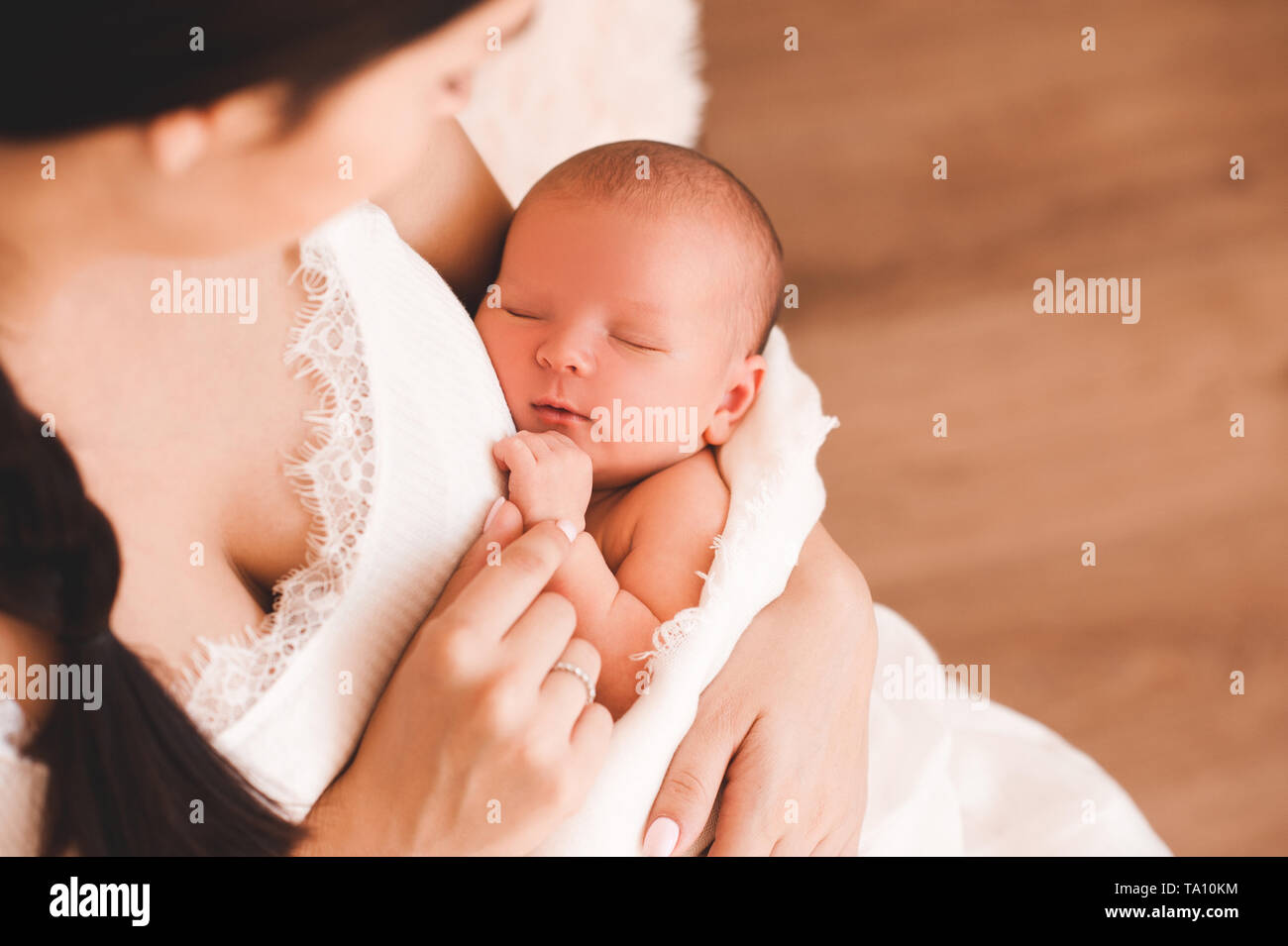 Cute Baby schläft auf Mutter Hände Nahaufnahme. Die Mutterschaft. Mutterschaft. Stockfoto