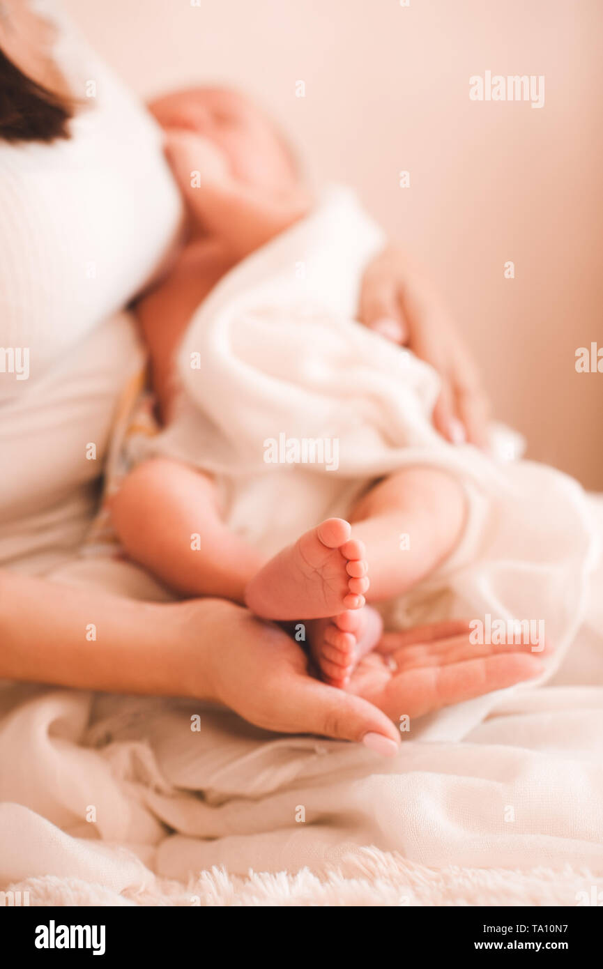 Mutter Holding baby Füße Nahaufnahme. Die Mutterschaft. Mutterschaft. Stockfoto