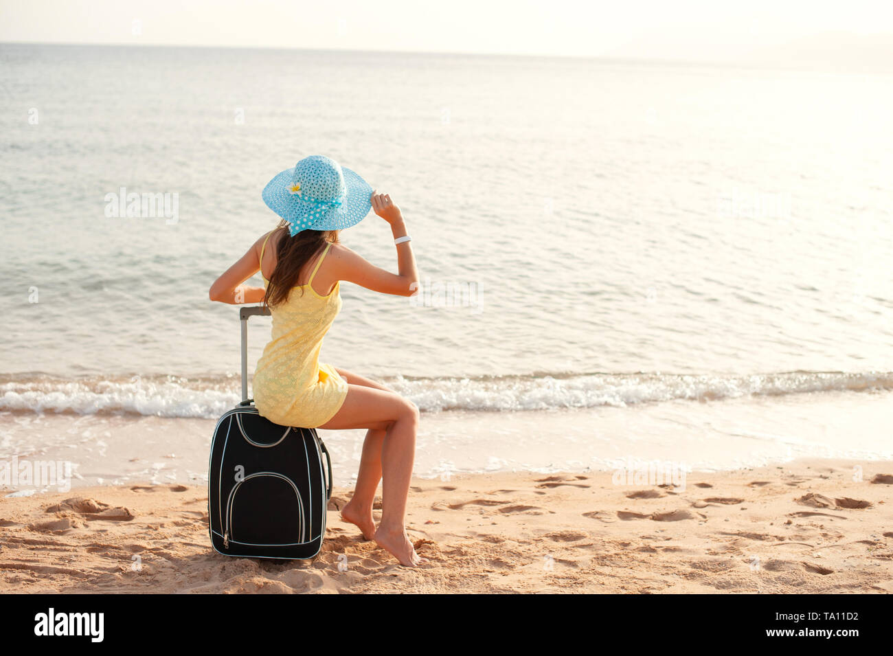 Reisen Urlaub und Personen Konzept - Frau Tourist in der Nähe von dem Meer sitzen auf Koffer und in Hut und beobachten die Sonne und alle Daumen hoch Stockfoto Reisen Urlaub und Personen Konzept - Frau Tourist in der Nähe von dem Meer sitzen auf Koffer und in Hut und beobachten die Sonne und alle Daumen hoch Stockfoto