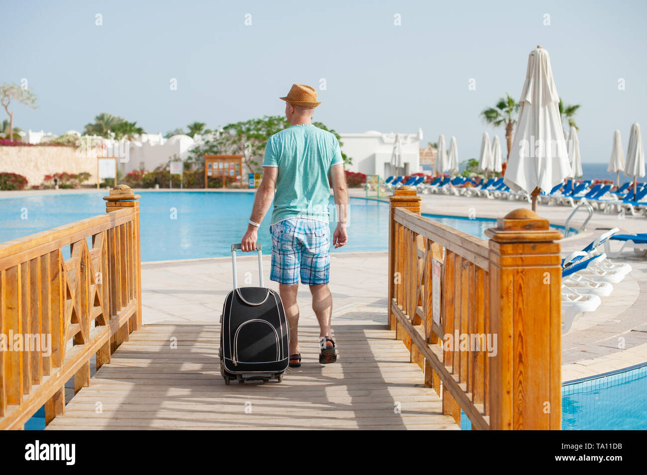 Portrait von glücklicher Mann mit Koffer in der Nähe von Pool. Konzept für Reise Tourismus und Entspannend Stockfoto Portrait von glücklicher Mann mit Koffer in der Nähe von Pool. Konzept für Reise Tourismus und Entspannend Stockfoto