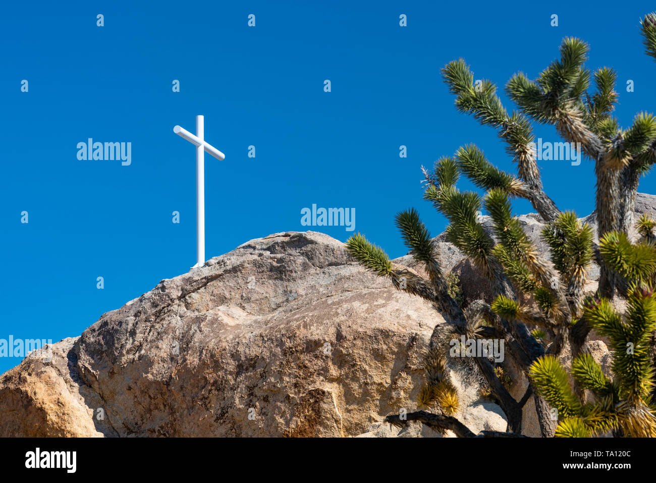 Ein weißes Kreuz auf einem Steinhaufen in der Mojave-Wüste, Kalifornien, USA. Stockfoto