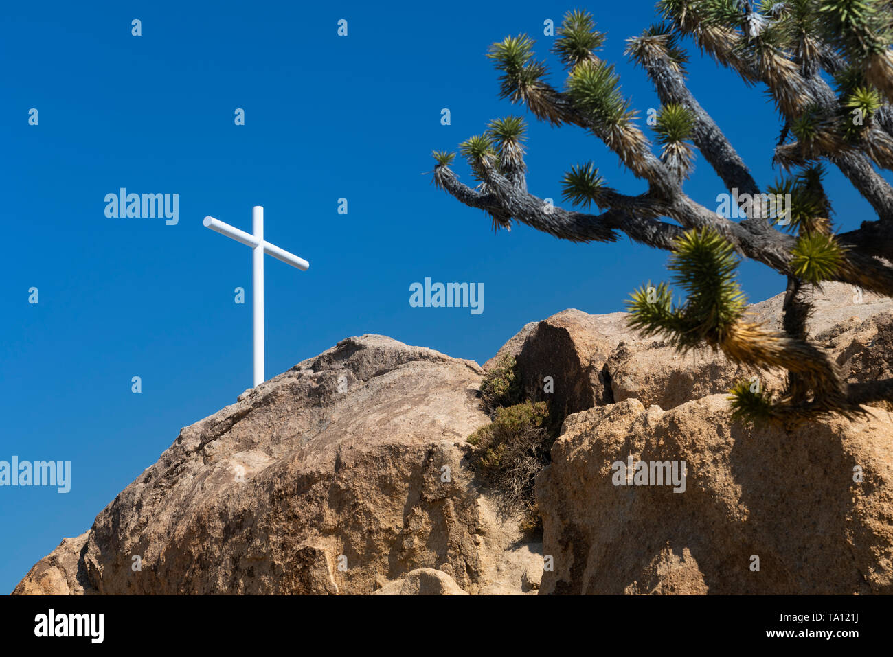 Ein weißes Kreuz auf einem Steinhaufen in der Mojave-Wüste, Kalifornien, USA. Stockfoto