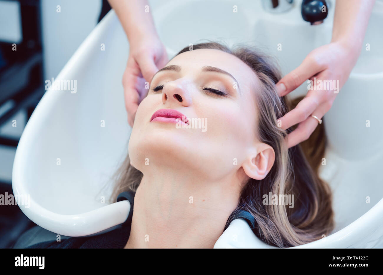 Waschen Friseur Haar von Client in Ihrem Shop Stockfoto