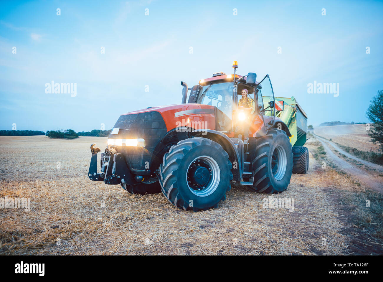 Landmaschinen und Schlepper auf einem abgeernteten Feld Stockfoto