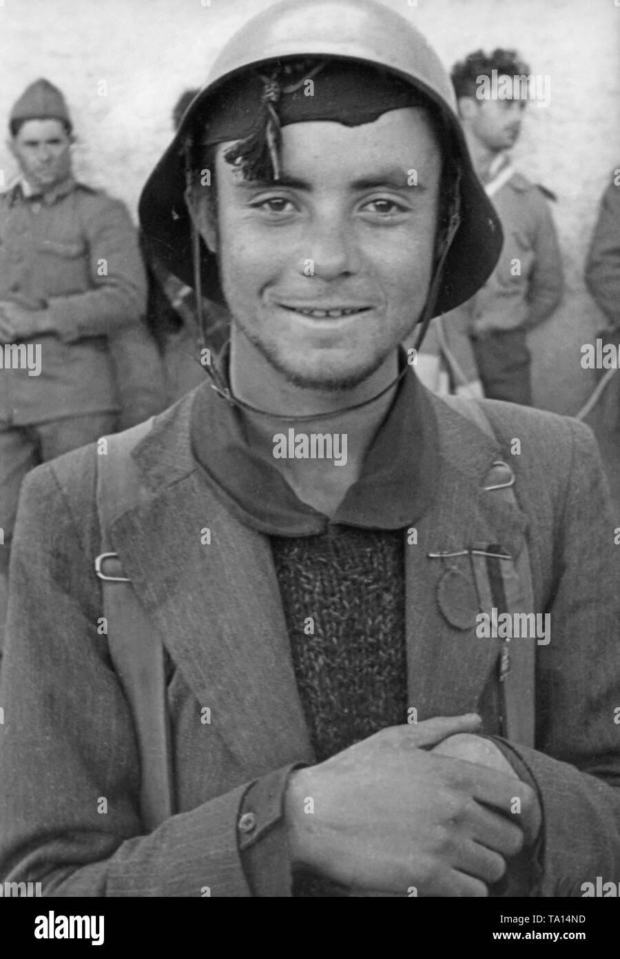 Portrait einer jungen Kämpfer des spanischen Nationalen Fraktion mit Stahlhelm, Abzeichen und Rucksack, Spanien, 1936. Stockfoto