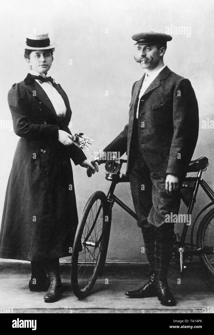 Elegante Radfahrer Paar in der Porty' Kleidung. Das Fahrrad hat einen Karbid Lampe vor. Undatiertes Foto. Stockfoto